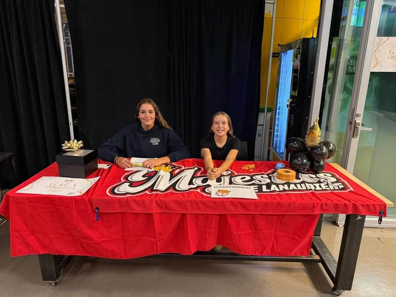 Deux joueuses à la table d'enregistrement, à l'entrée du gala